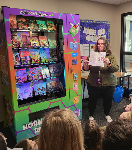IMC Director Heidi Meyer shows a class the new book vending machine