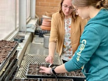 a teacher and a student plant seeds in the RCHS greenhouse
